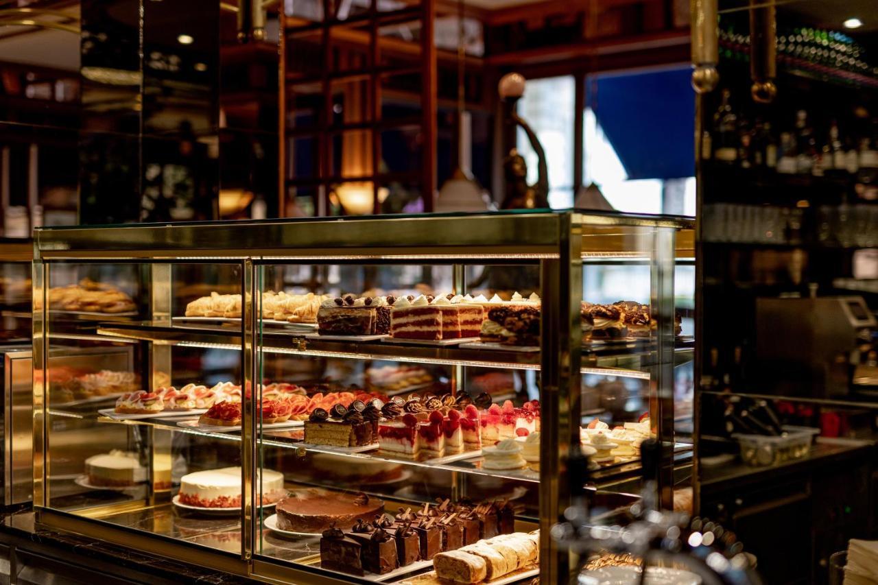 แกรนด์โฮเต็ล พัปป์ Hotel การ์โลวีวารี ภายนอก รูปภาพ The photo displays a beautifully organized glass display case filled with an assortment of pastries and cakes. There are various types of desserts, including layered cakes, chocolate treats, and fruit-topped confections. The setting appears to be a c