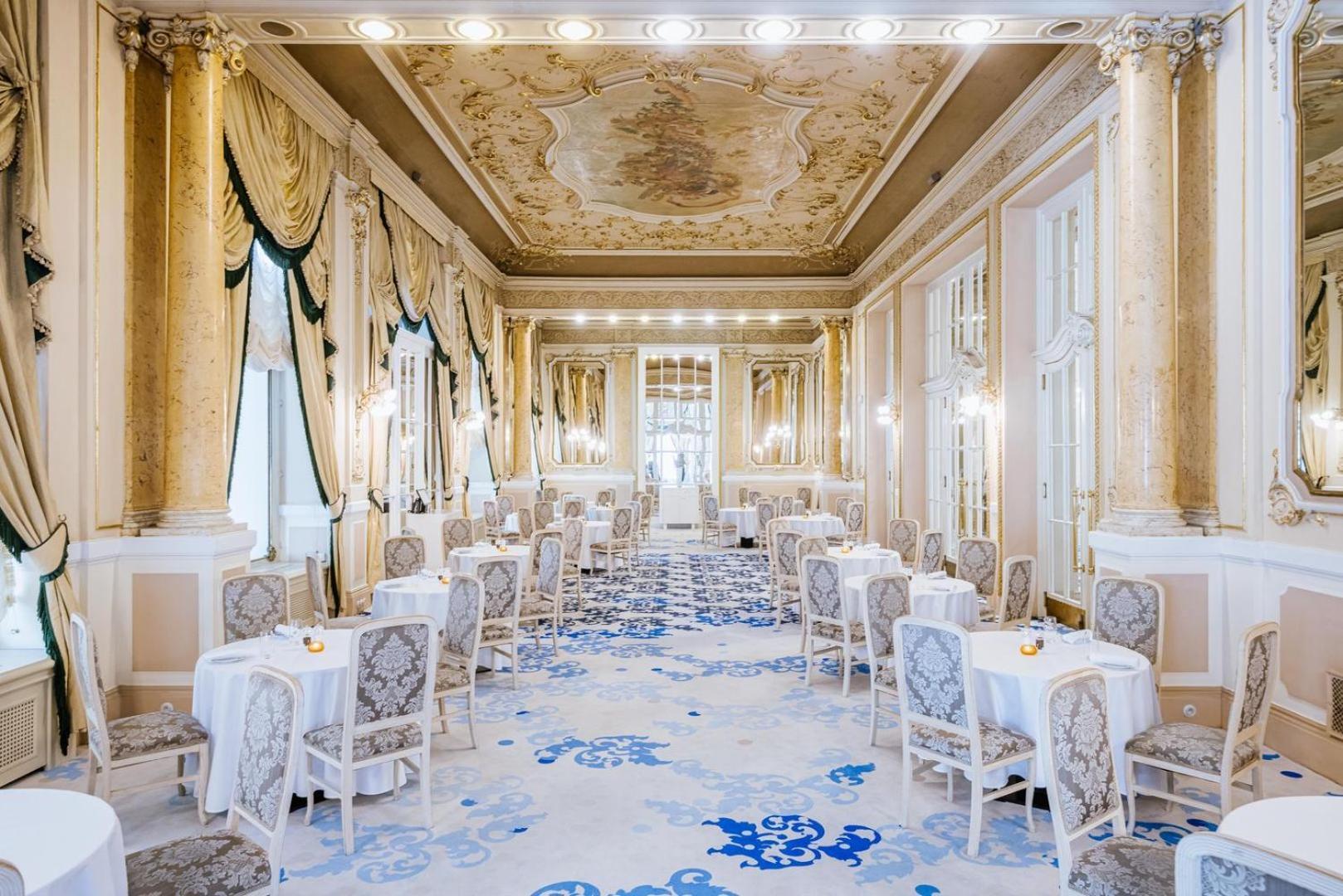 แกรนด์โฮเต็ล พัปป์ Hotel การ์โลวีวารี ภายนอก รูปภาพ The photo shows an elegantly designed dining room with a luxurious and classic aesthetic. The space features ornate details such as a beautifully painted ceiling, decorative moldings, and large windows that allow natural light to flood in. The decor 